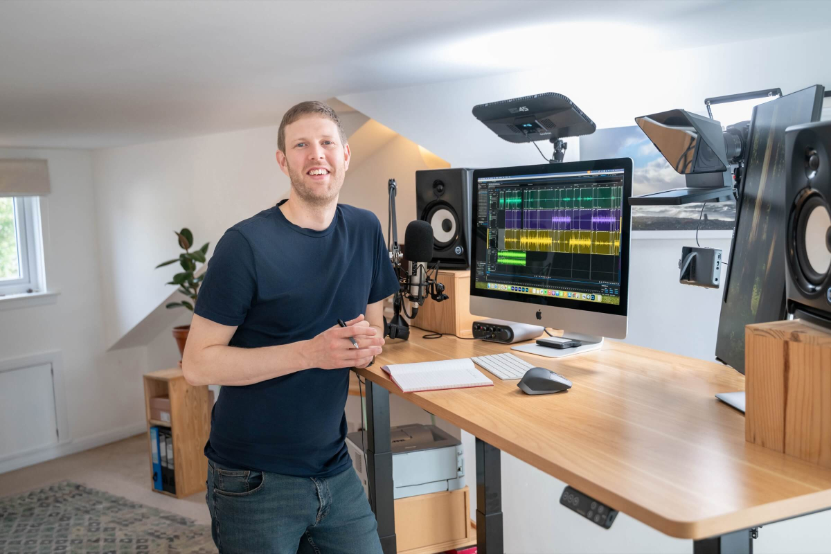 Rory, The Podcast Coach's head of audio editing a podcast at his standing desk.