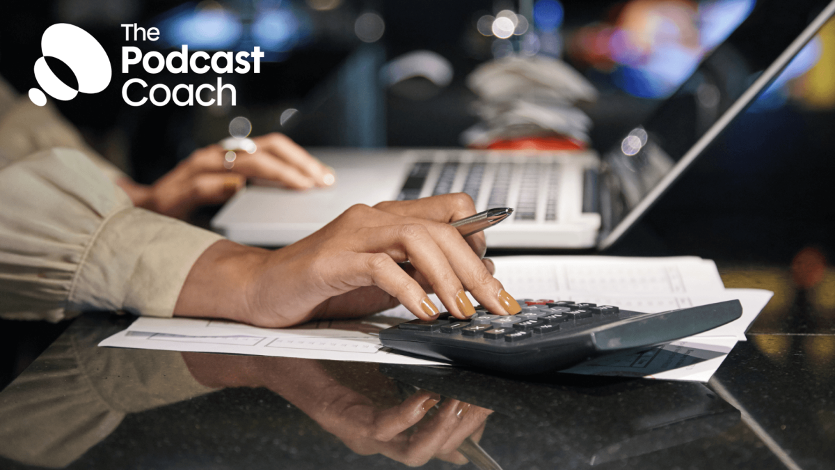 An image of someones hand on a calculator as they work out a budget for their podcast.